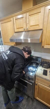 Technician checking a range in a Denver Metro kitchen