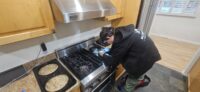 Technician working at a gas range in a Denver kitchen