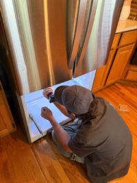 Technician reviewing a wiring diagram during refrigerator repair