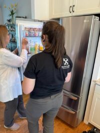 Wilson & Myers technician explaining refrigerator findings to a homeowner in Denver Metro
