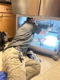 Technician inspecting a freezer compartment with a work light