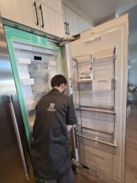 Technician examining refrigerator shelves and air vents