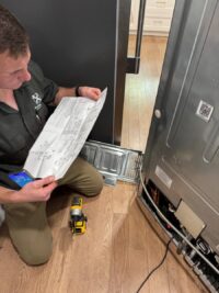 Technician reviewing the wiring diagram before a refrigerator repair