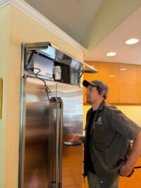 Technician discussing refrigerator repair options with a homeowner in Denver Metro