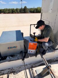 Technician servicing a rooftop condensing unit