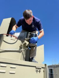 Technician working on a rooftop condensing unit in Denver Metro