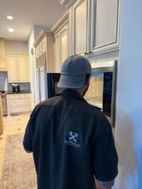 Technician diagnosing a wall oven in a Denver kitchen