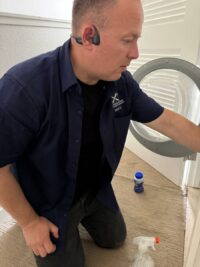 Technician opening a front load washer to check wash performance