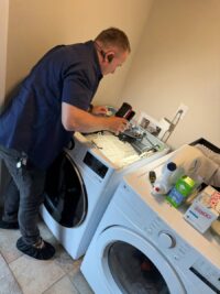 Technician reviewing washer settings during a service call