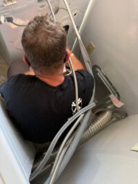 Technician examining the tub of a top load washer